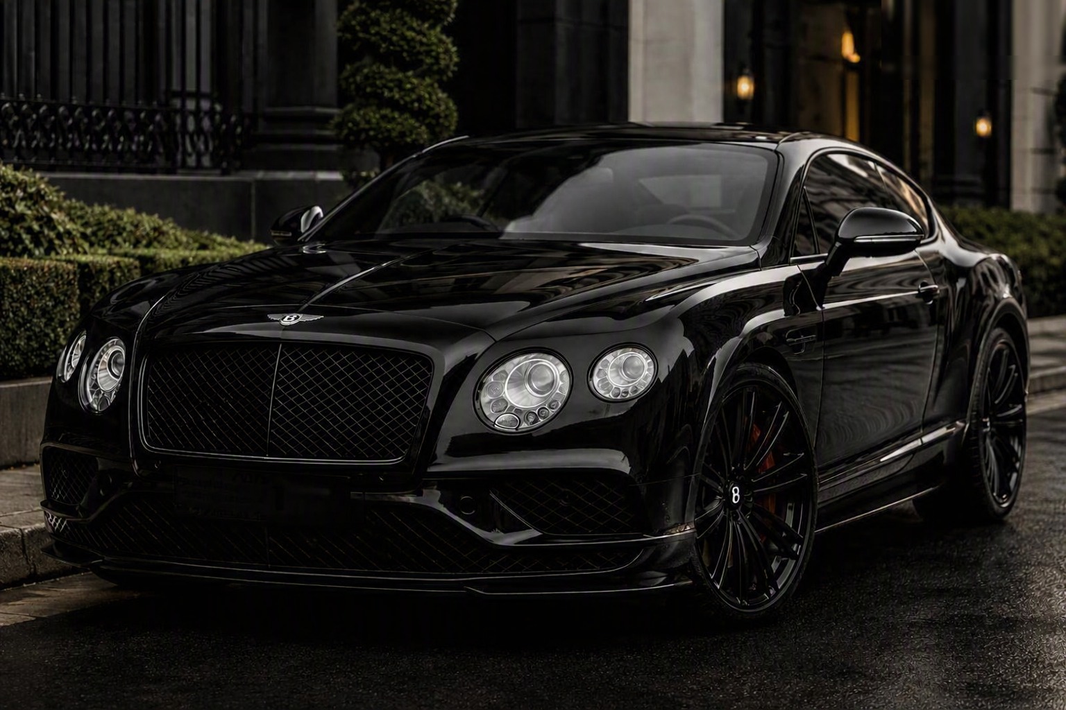 Black Bentley Continental GT parked outside a building